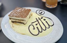 two pieces of cake sitting on top of a white plate next to a glass filled with liquid