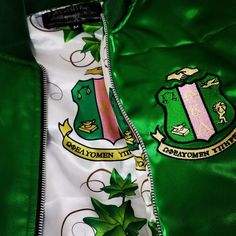 green and white jacket with coat emblems on it