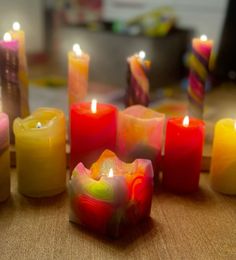 many different colored candles sitting on top of a table