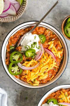 two bowls filled with chili and cheese