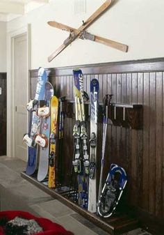 there are many skis and snowboards on the wall next to each other in this room