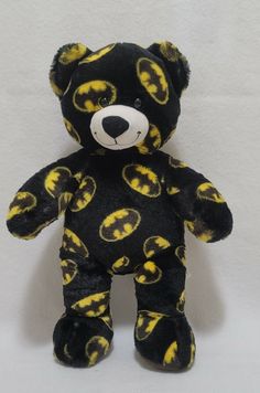 a black and yellow teddy bear with batman symbols on it