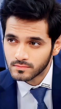 a close up of a person wearing a suit and tie with a serious look on his face