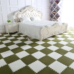 a white bed sitting on top of a green and white checkered floor