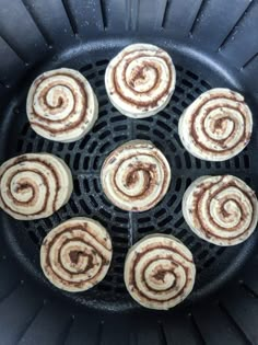 several cinnamon rolls sitting on top of a grill