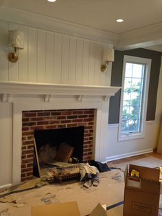 an empty room with a fire place and boxes on the floor in front of it