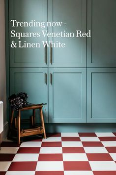 a room with blue cabinets and red and white checkerboard flooring in it