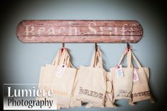 several bags hanging from a wooden sign that says beach surf on it's side