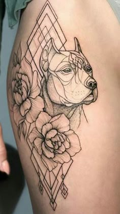 a woman's thigh with a dog and flowers on the side, in black and white