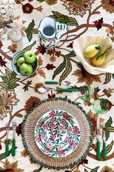 a table topped with plates and bowls filled with fruit on top of a table cloth