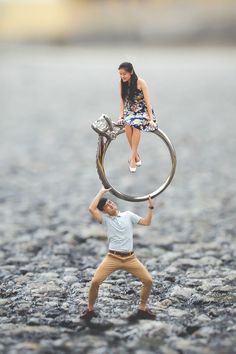 a man and woman standing on top of a giant metal object