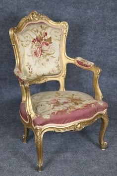 an ornately decorated chair with pink and gold fabric on the back, against a blue background