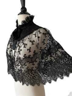 Very lovely antique Victorian cape/capelet, beautiful black lace gathered with a  scalloped hemline, longer in back, the lace is around the collar is backed with black silk  and comes to a point in front and back. The neckline and collar are trimmed with black glass/jet beadwork in a scalloped pattern. The cape closes in front with a hook/eye closure at the neck and a black silk ribbon bow. It has a high neck collar trimmed in black lace.  Condition: Excellent antique condition. Measurements:  1 Formal Black Capelet, Black Capelet For Evening Wear, Elegant Black Capelet With Cape Sleeves, Black Capelet For Costume, Elegant Black Capelet For Party, Elegant Black Formal Capelet, Elegant Black Party Capelet, Vintage Lace With Lace Trim For Evening, Victorian Fitted Scalloped Lace