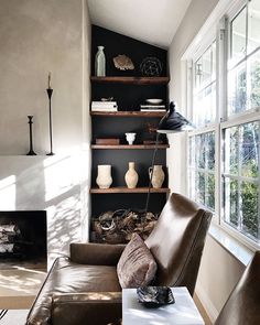 a living room filled with furniture and a fire place in front of a large window