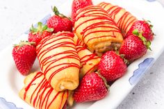 strawberries and pastries on a plate with drizzled red icing