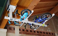 a bike hanging from the ceiling in a room with wood paneling and exposed rafters