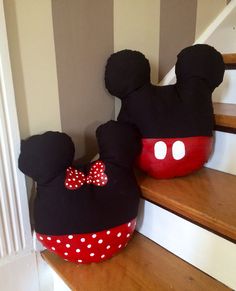 two stuffed mickey mouses are sitting on the stairs