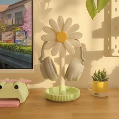 there is a flower and headphones on the table next to a potted plant