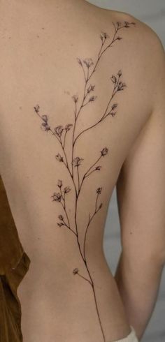 the back of a woman's body with small flowers on her left side,