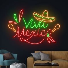 a neon sign that says vive mexico on the wall next to a couch and chair