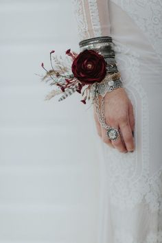 a close up of a person's hand holding a bracelet with flowers on it