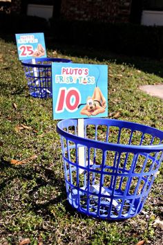 two blue baskets sitting in the grass with signs on them that say pluto's toys