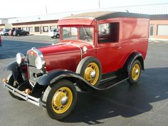 an old red truck parked in a parking lot