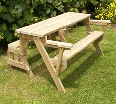 a wooden picnic table sitting in the grass