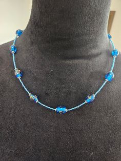 a blue beaded necklace on a mannequin