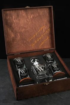 three glass bottles in a wooden box with writing on it