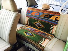 the interior of a car with a multicolored rug on the floor and seat