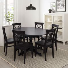 a dining room table and chairs in front of a window