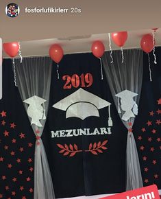 graduation decorations with balloons and streamers hanging from the ceiling in front of black backdrop