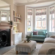 a living room filled with furniture and a fire place in front of a window covered in bookshelves