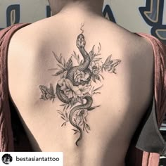 a woman's back with a snake and flowers on it