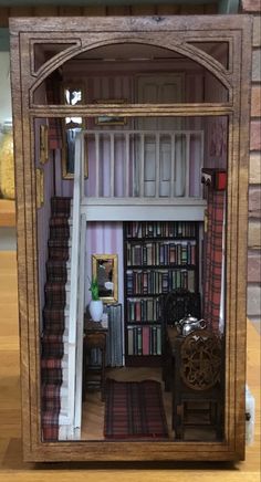 a doll house with stairs and bookshelves