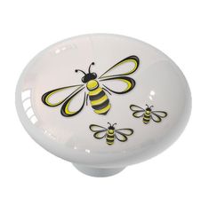 a white cabinet knob with yellow and black bees painted on the front part of it