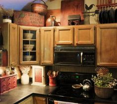 a kitchen with wooden cabinets and black stove top oven in the center, filled with pots and pans