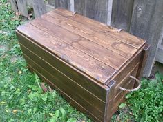 an old wooden box sitting in the grass