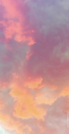 an airplane is flying in the sky with pink and blue clouds behind it at sunset