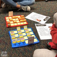 two children sitting on the floor playing with an activity board and matching numbers to match them