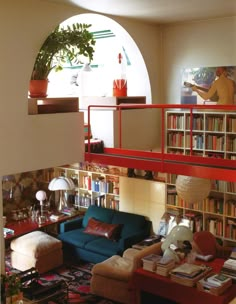 a living room filled with furniture and bookshelves next to a tall arched window