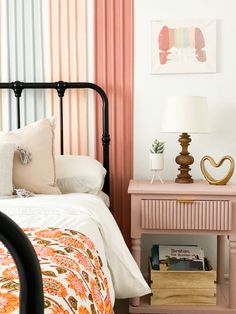 a bedroom with pink, white and gold striped curtains on the wall behind the bed