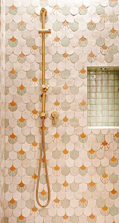 a bathroom with a shower head, window and tiled wall