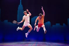 two tennis players jumping in the air with rackets