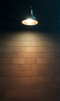 a light that is on the side of a brick wall