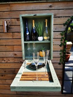 an outdoor bar with wine glasses and bottles