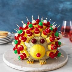 a cake shaped like a hedgehog with fruit on it and toothpicks in the shape of teeth