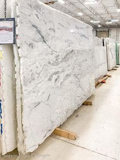 a large white marble slab is being displayed in a store with some signs on the wall