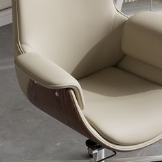 an office chair with a wooden frame and leather upholstered seat